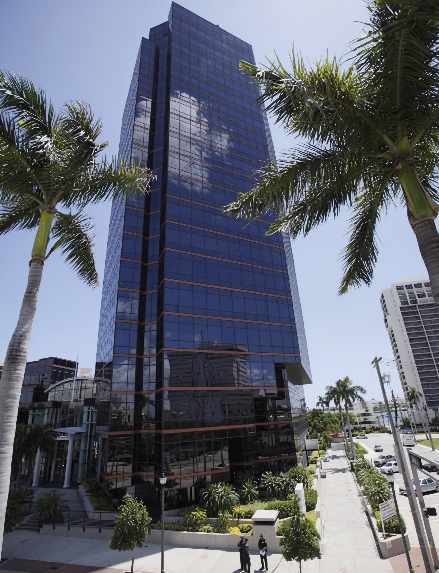 A glass office tower among palm trees in downtown West Palm Beach