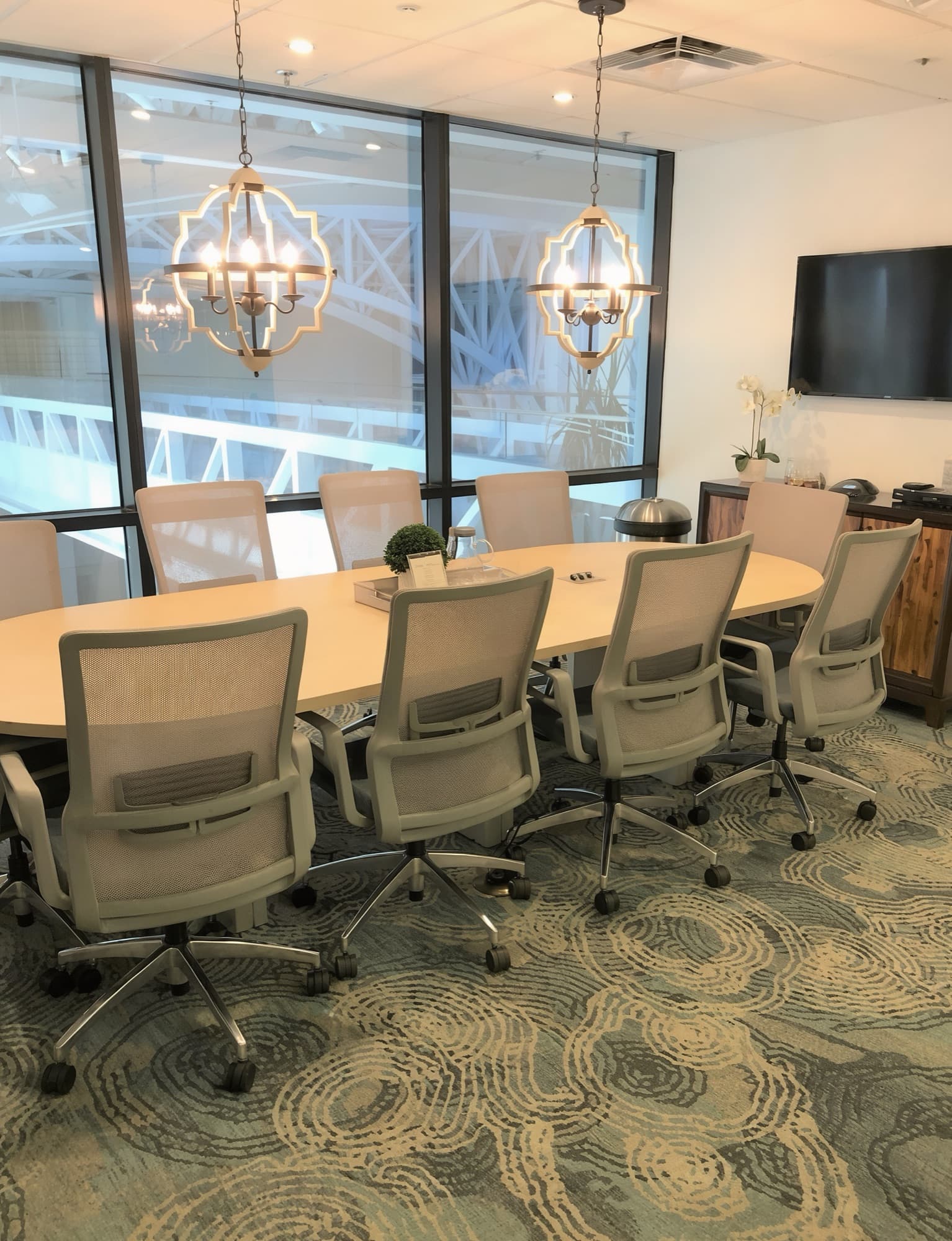 A conference room with a long table beneath two chandeliers